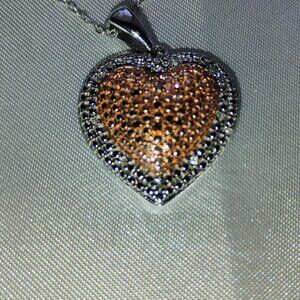 Heart pendant in sterling silver.  Red diamond accents